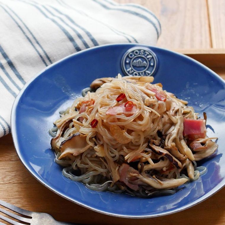 青い皿に盛り付けられたしらたきペペロンチーノ