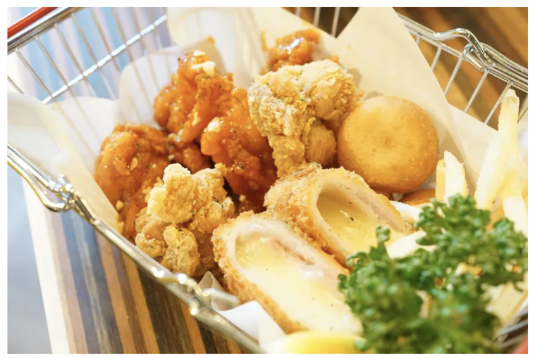 バスケットの中にチキンやチーズボールなどの揚げ物が入っている