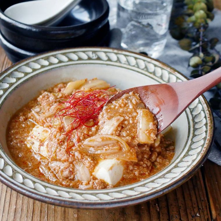 ベージュの皿に盛り付けられた絹豆腐のキムチあんかけ