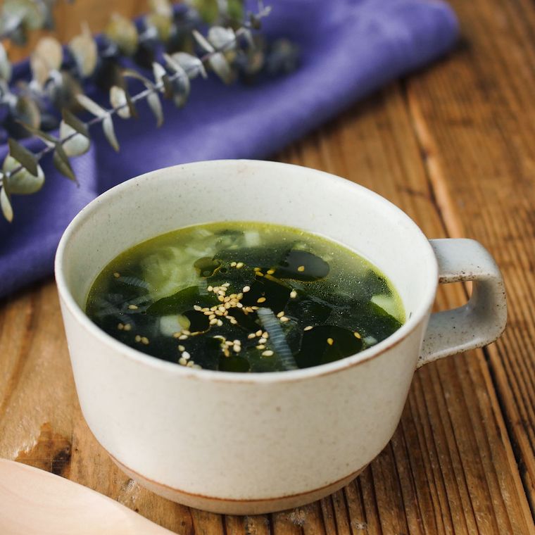 白いカップに盛りつけられたわかめと長ねぎの中華風スープ