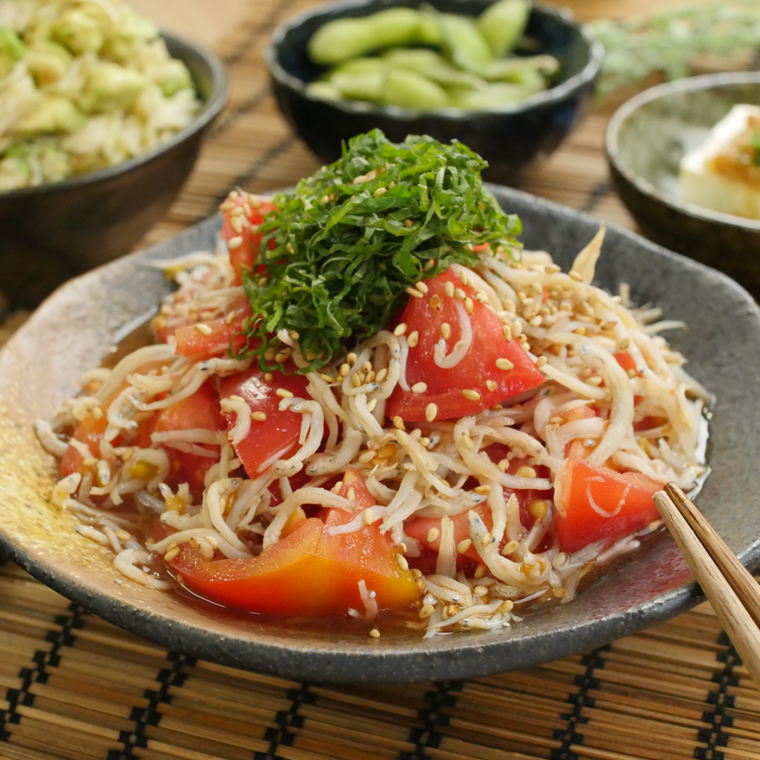 石目肌の皿に盛りつけられたしらすとトマトのポン酢和え