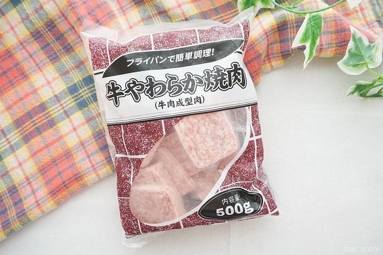 牛やわらか焼肉のパッケージをテーブルに置き、緑の葉とチェック柄の布を添えた様子