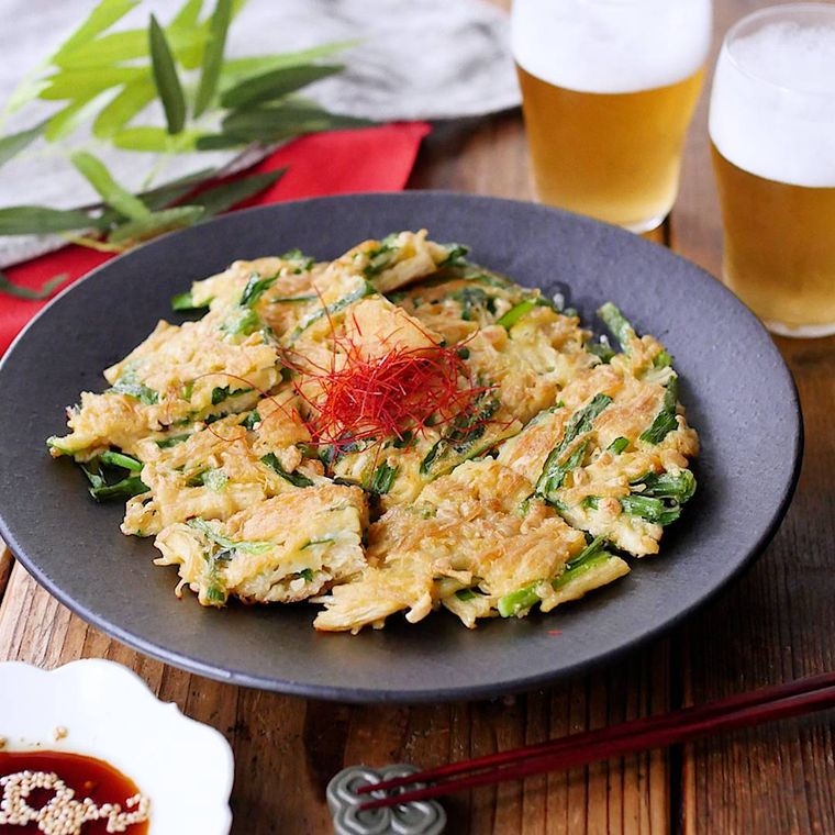 黒い丸皿に盛られたえのきだけとニラのチヂミ