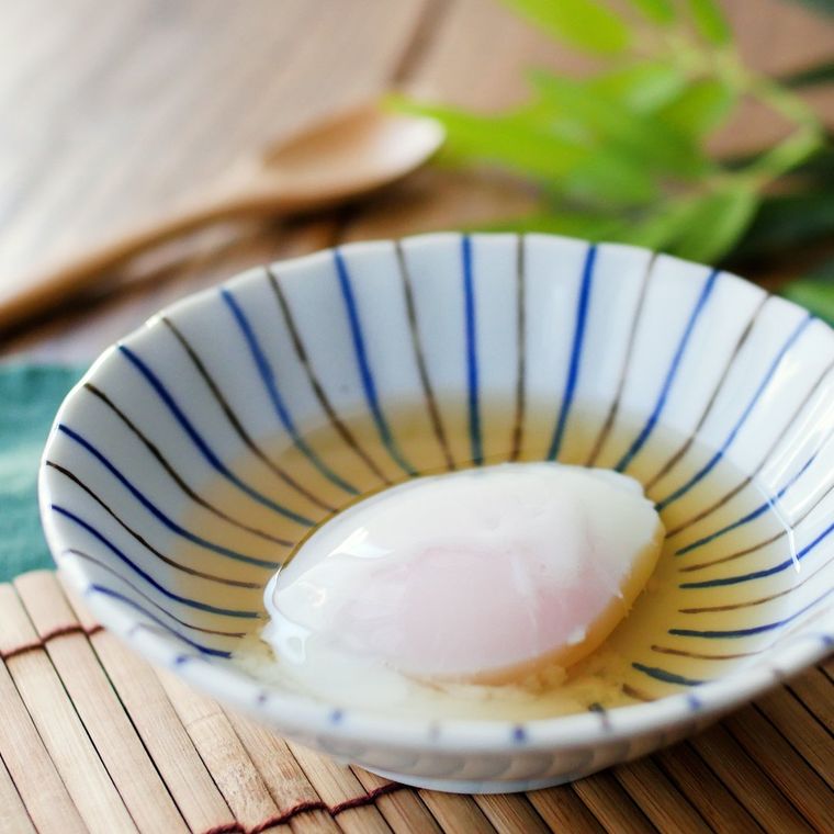 縞模様の器に、殻から出した温泉卵が入っており、だしがかけられている