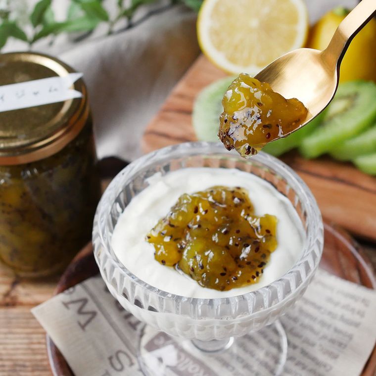 ガラスの器に入ったヨーグルトにキウイジャムをトッピングしている様子