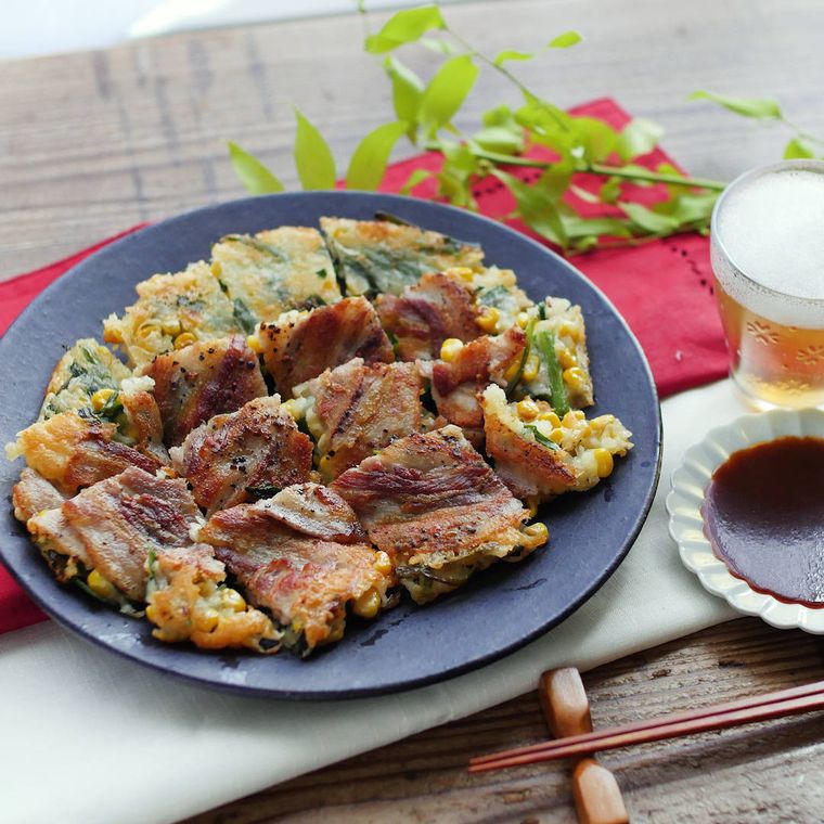 青い皿に盛られたチヂミと、その横に添えられたビールとたれ