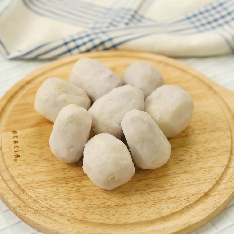 丸い木のまな板の上に、皮をむいてゆでた里芋が8個置かれている