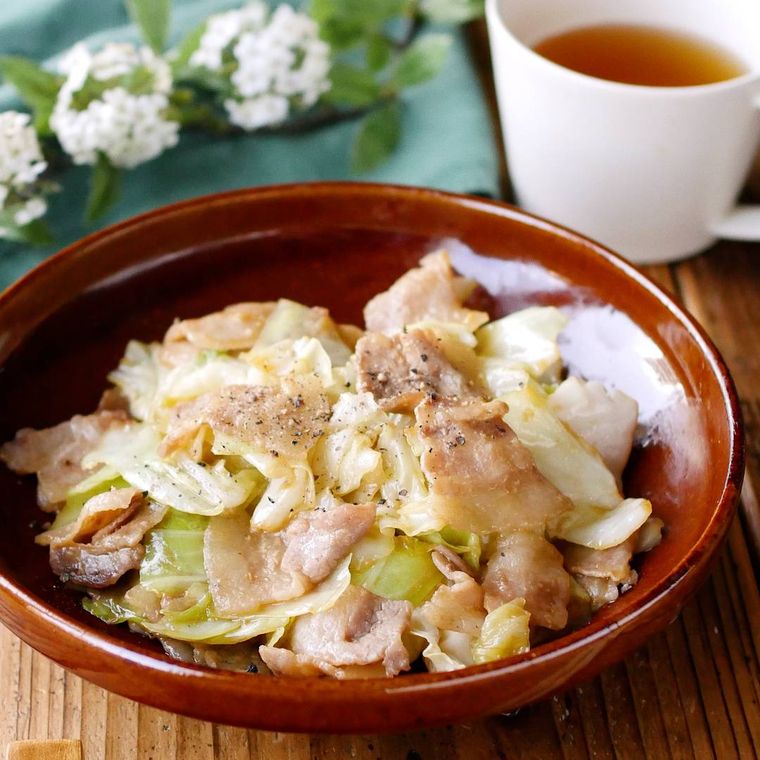 茶色い丸皿に盛り付けた豚バラ肉とキャベツのにんにくみそ炒め