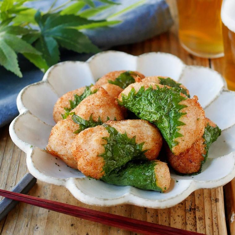 白い皿に盛り付けられている山芋と明太子の大葉包み揚げ