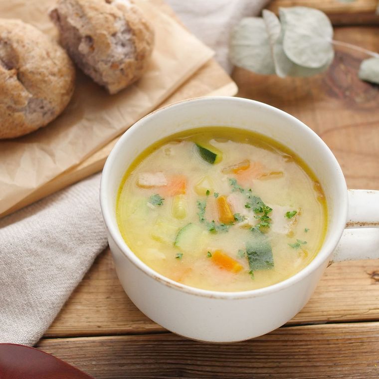 白いカップに盛られたズッキーニやにんじんなどの白みそミネストローネ