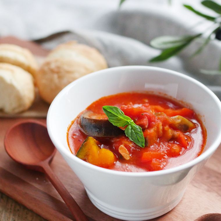 白い器に盛られたズッキーニやベーコンなどのラタトゥイユ風スープ