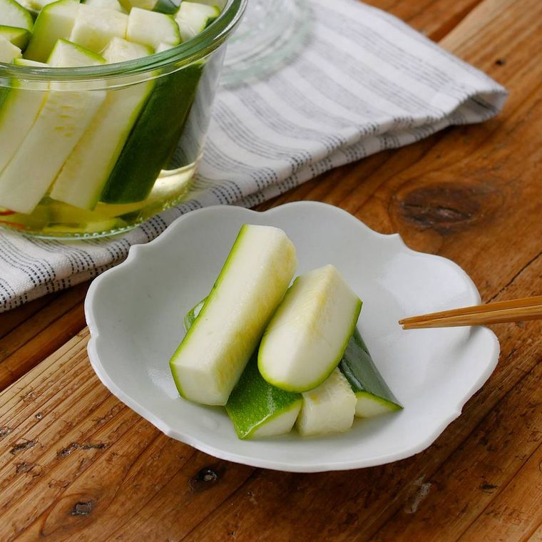 白い豆皿に乗っているズッキーニのピクルス