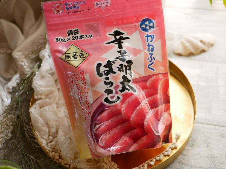 ゴールドプレートのうえに置かれたコストコのかねふく辛子明太ばらこパッケージ