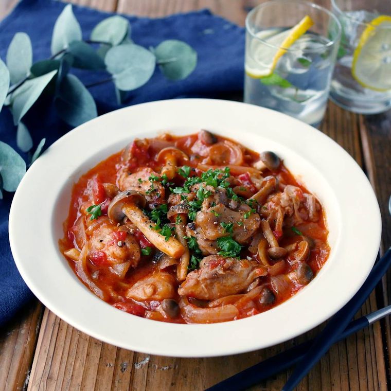 白い皿に盛り付けられた鶏もも肉のトマトみそ煮