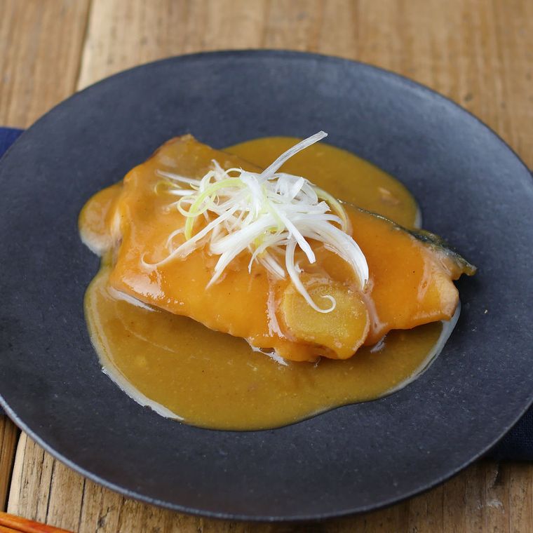 黒い皿に盛られたぶりのみそ煮