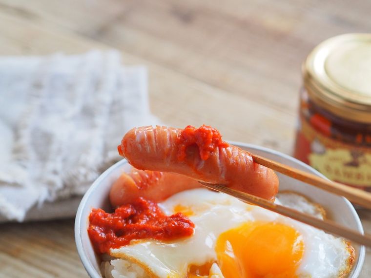 サンバルを塗ったウインナーを箸で持ち上げる様子