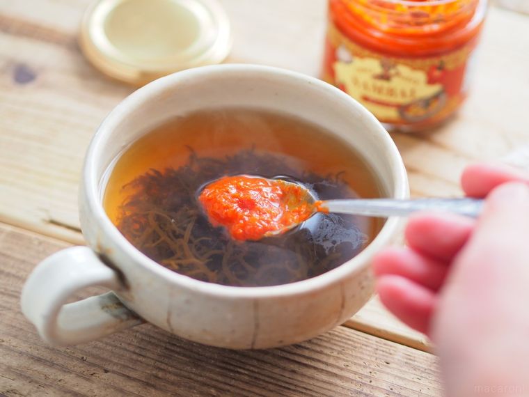 スプーンですくったサンバルをスープに溶かす様子