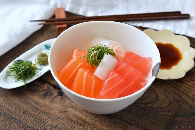 テーブルに置いた「まるで魚」の海鮮丼、薬味皿、箸、醤油皿