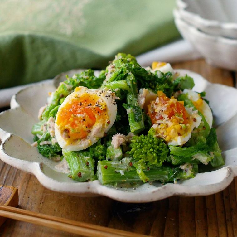 白い花形の皿に盛り付けられた菜の花と卵のマヨマスタードサラダ