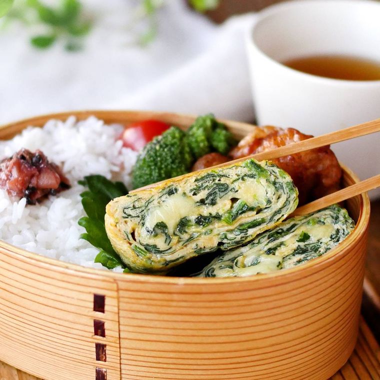 わっぱの弁当箱に、ごはん、梅干し、ブロッコリー、ミニトマト、ほうれん草入り卵焼きなどが詰め込まれている