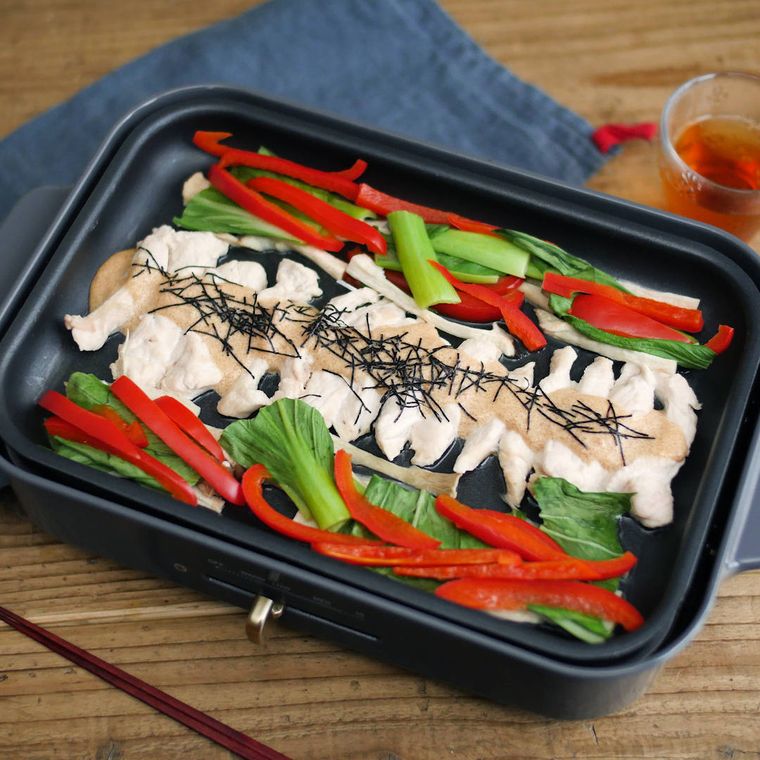 黒色のホットプレートの上にできあがっている明太チキンホットサラダ