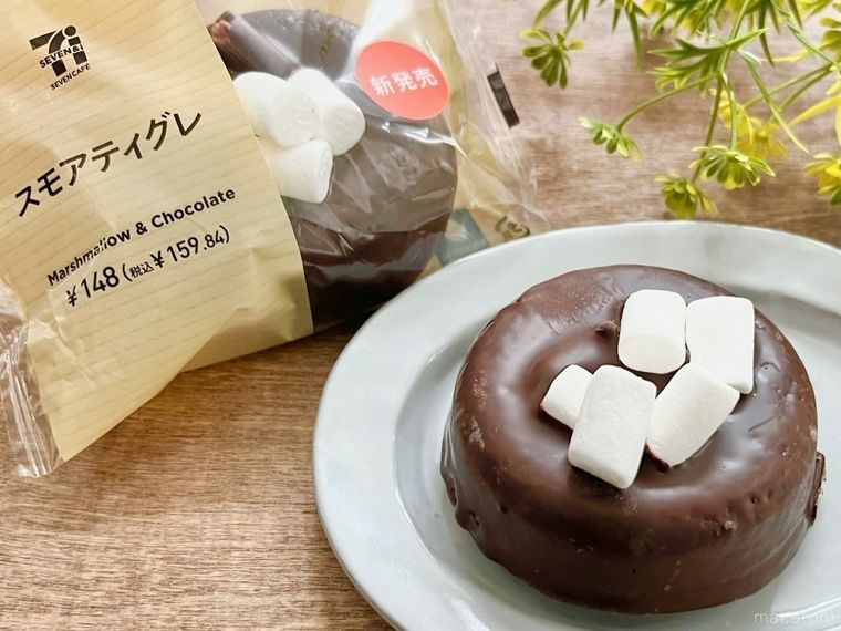 グレーの皿にマシュマロがトッピングされたチョコレートケーキが置かれ、横には袋に入ったチョコレートケーキが並べられている