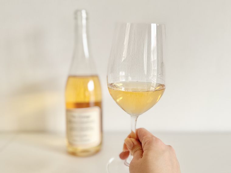 グラスに注いだフランス オーパシオ オレンジワインとボトル