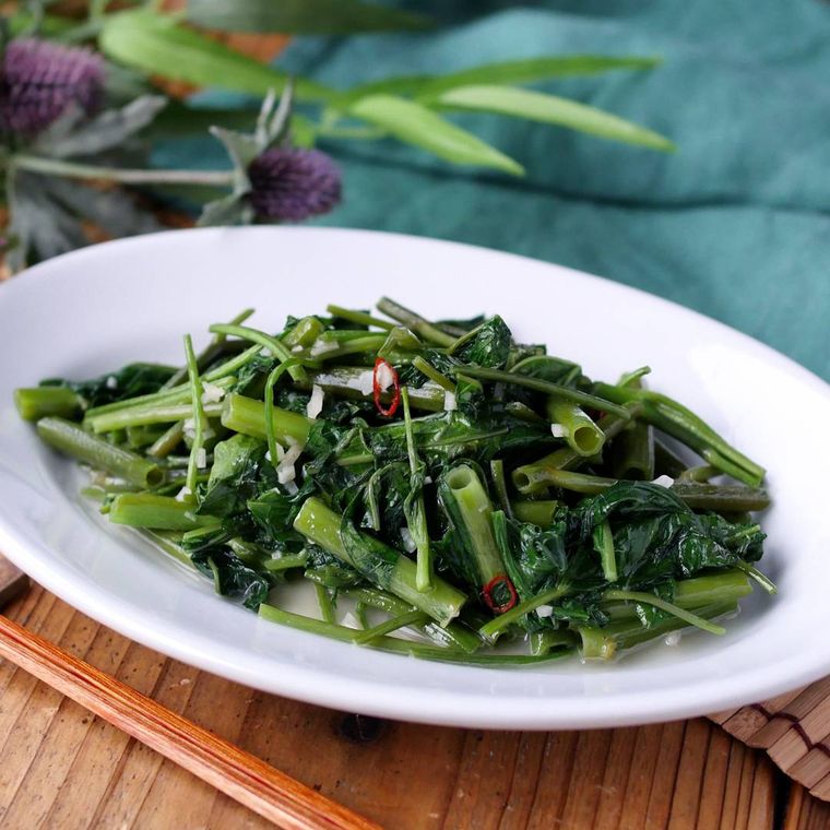 白い平皿に盛られた、空芯菜炒め