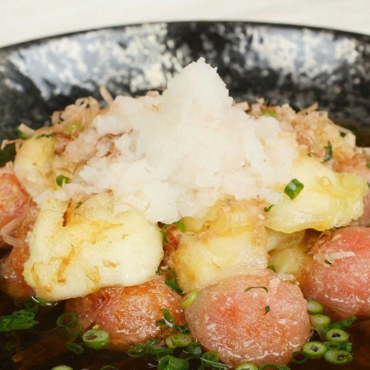 だし汁に浸かっている揚げモッツァレラチーズとトマト