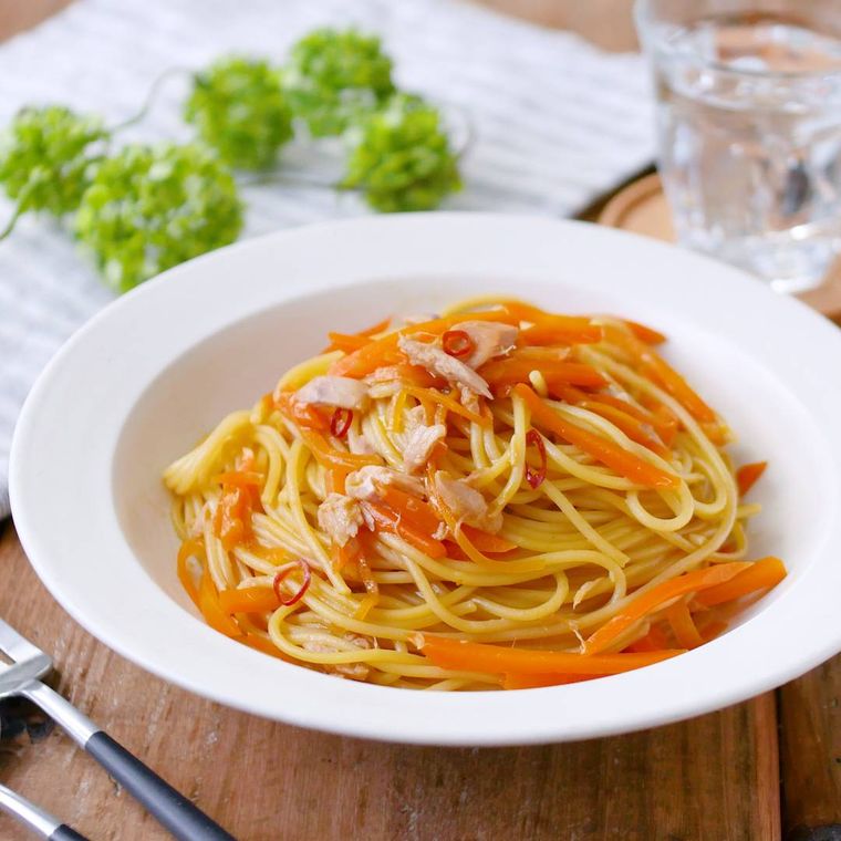 深めの白い丸皿に盛りつけられたにんじんとツナの和風ペペロンチーノ