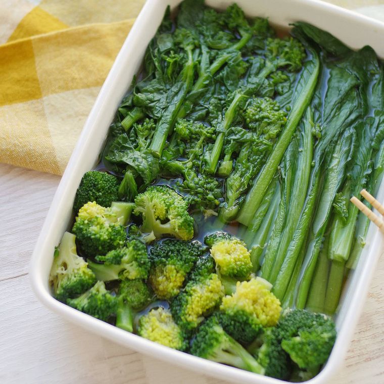 白いバットに入った小松菜と菜の花のおひたし