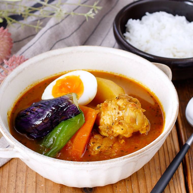 白い深皿に盛り付けられた手羽元とごろごろ野菜のスープカレー