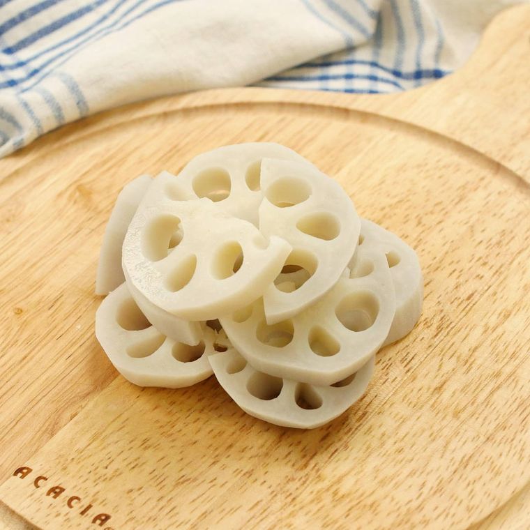 カッティングボードの上で半月切りされたれんこん