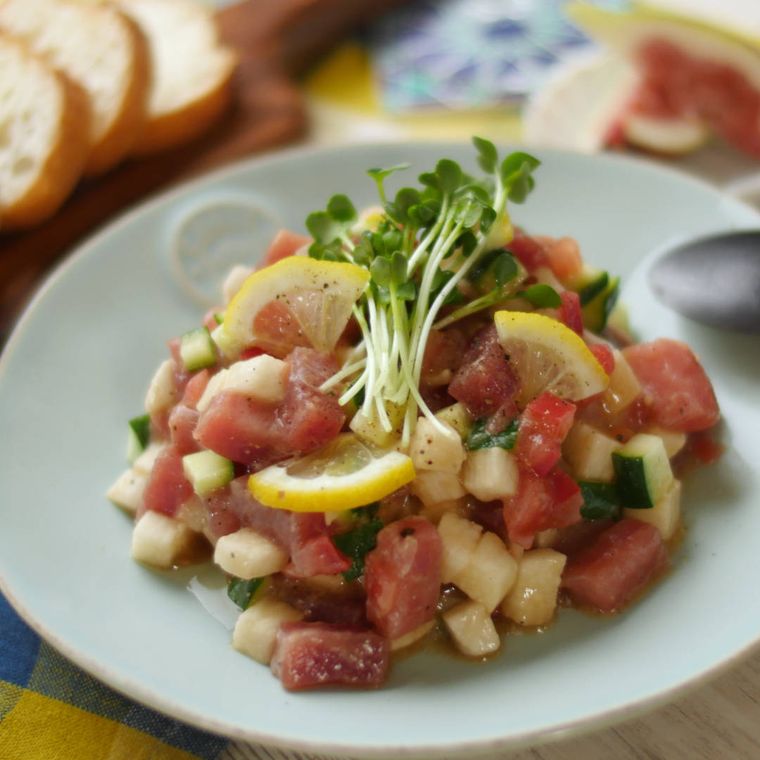 水色の丸皿に長芋とまぐろのタルタルが盛られ、机の上に置かれている