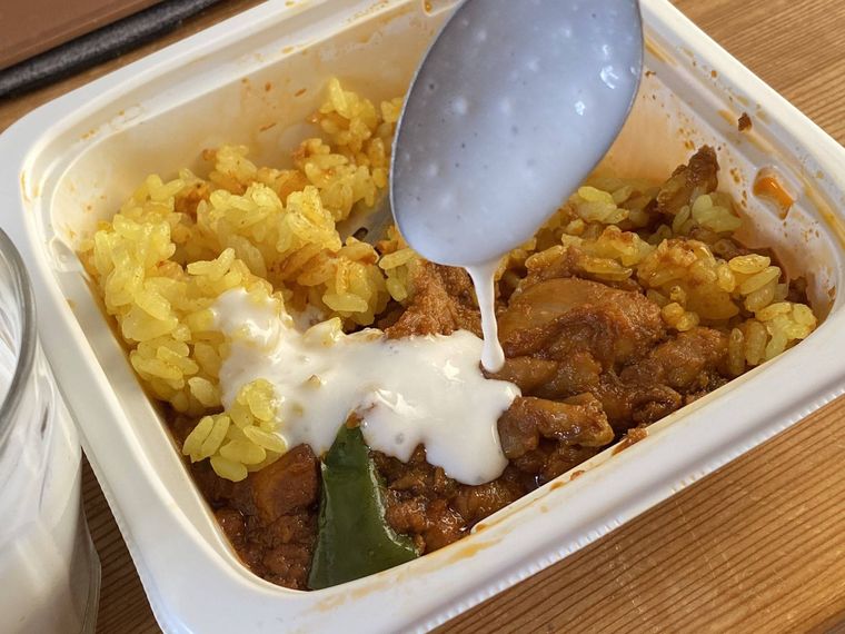 チキンカレーおむすびが入ったチキンマサラにヨーグルトをかけている