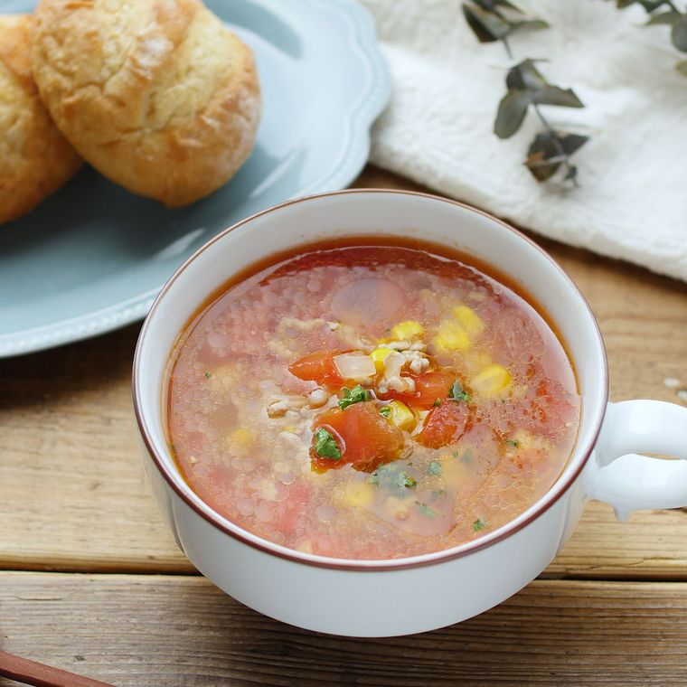白いスープカップに入った豚ひき肉とトマトのコンソメスープ
