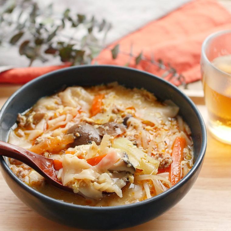 黒い器に盛り付けた豚ひき肉とワンタンの酸辣湯スープ