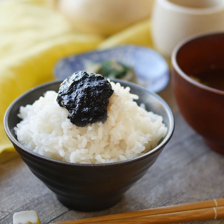 黒い茶碗に盛り付けたごはんにのった海苔の佃煮