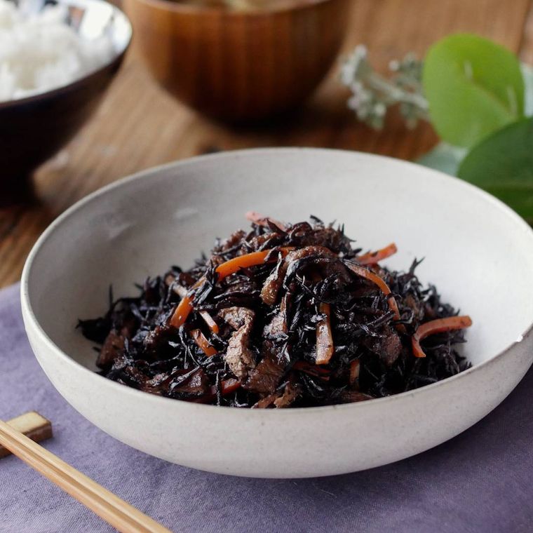 白い器に盛られた、にんじんと油揚げ入りのひじき煮