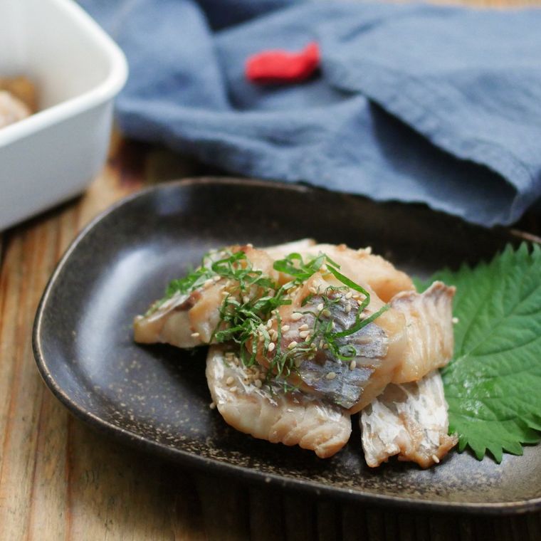 黒色の皿に盛られたたらの梅しそみりん焼き