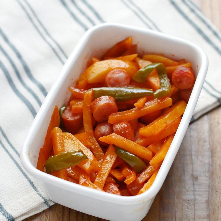 白い容器によそったじゃがいもとソーセージの炒め物