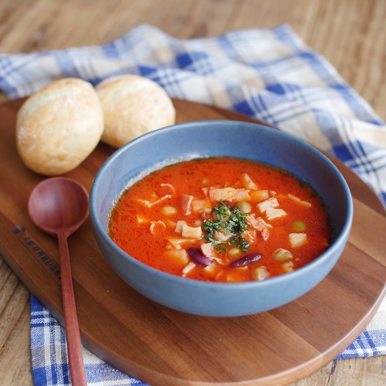 器に盛られた豆とれんこんのトマトスープと、添えられたパン