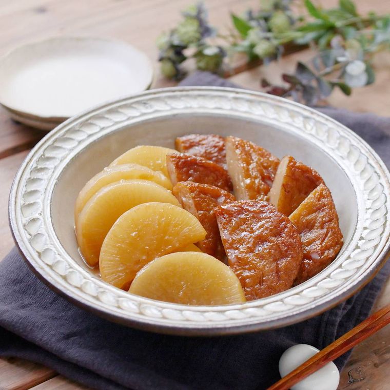 洋風の円形の皿に盛り付けられている大根とさつま揚げの味しみ煮物