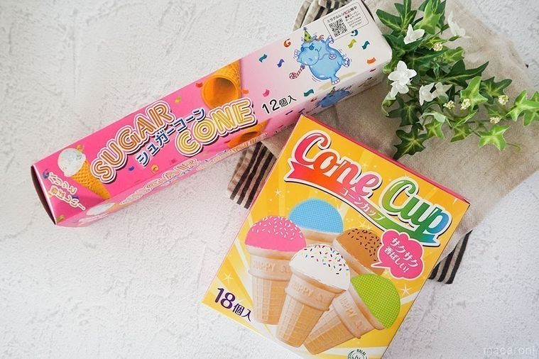 コーンカップとシュガーコーンのパッケージに布と緑の葉を添えてテーブルに並べた様子