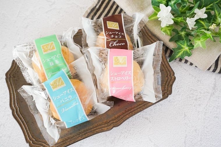 ブロンズの皿に並べたシューアイスに布と緑の葉を添えてテーブルに並べた様子