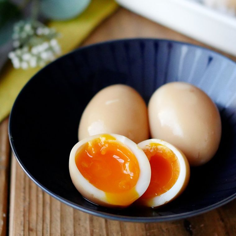 紺色の皿に盛り付けられためんつゆとポン酢の煮卵