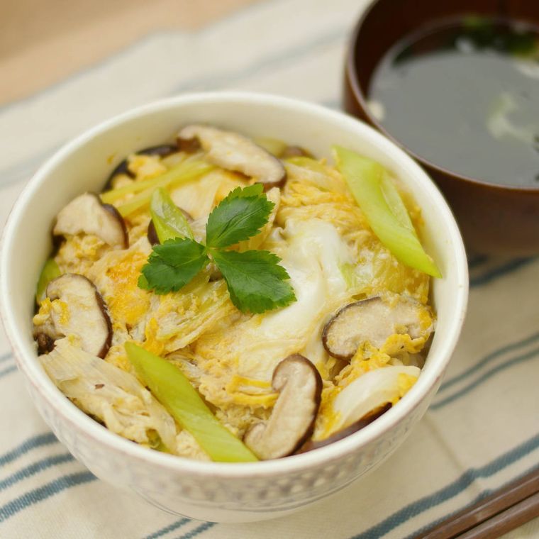白い丼鉢に盛りつけられた長ねぎとしいたけの卵丼