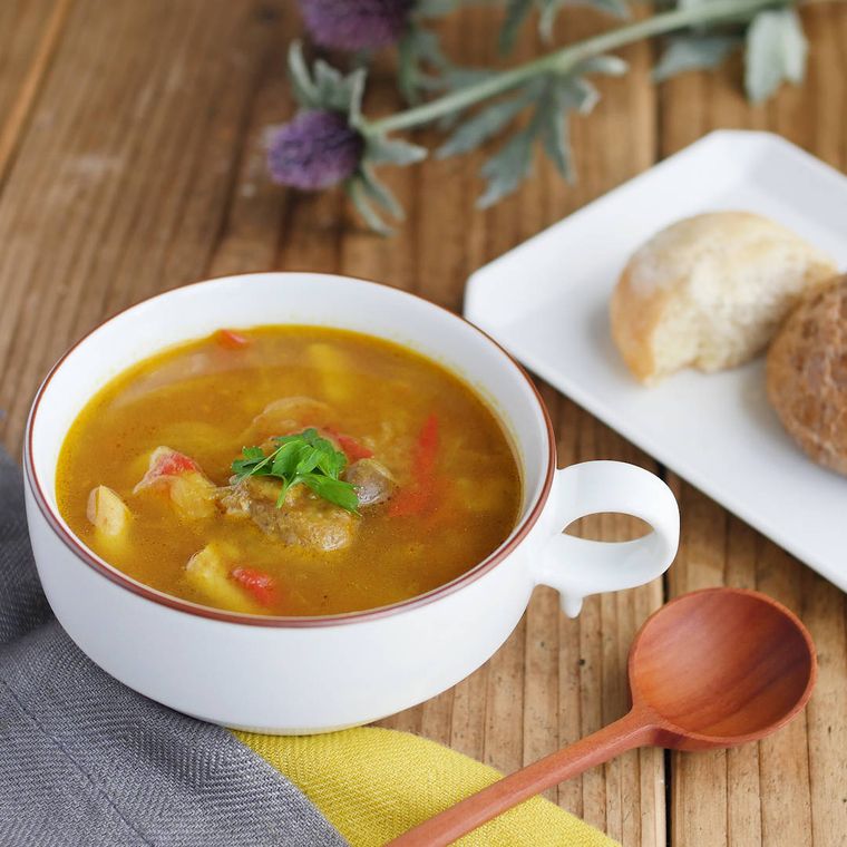 白いスープマグに入れたきのことトマトのカレースープ