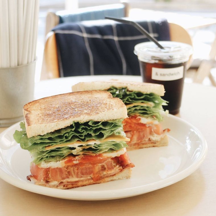 白い器にのったベーコン、レタス、トマトが挟まったBLTサンドイッチ