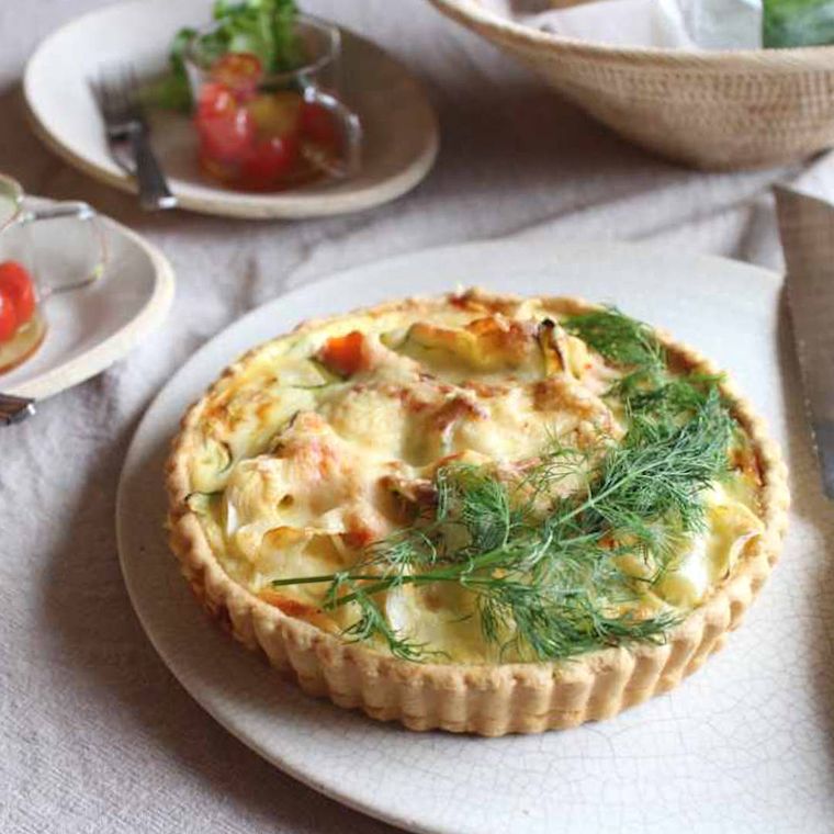 ハーブをトッピングしたホールのキッシュがある食卓